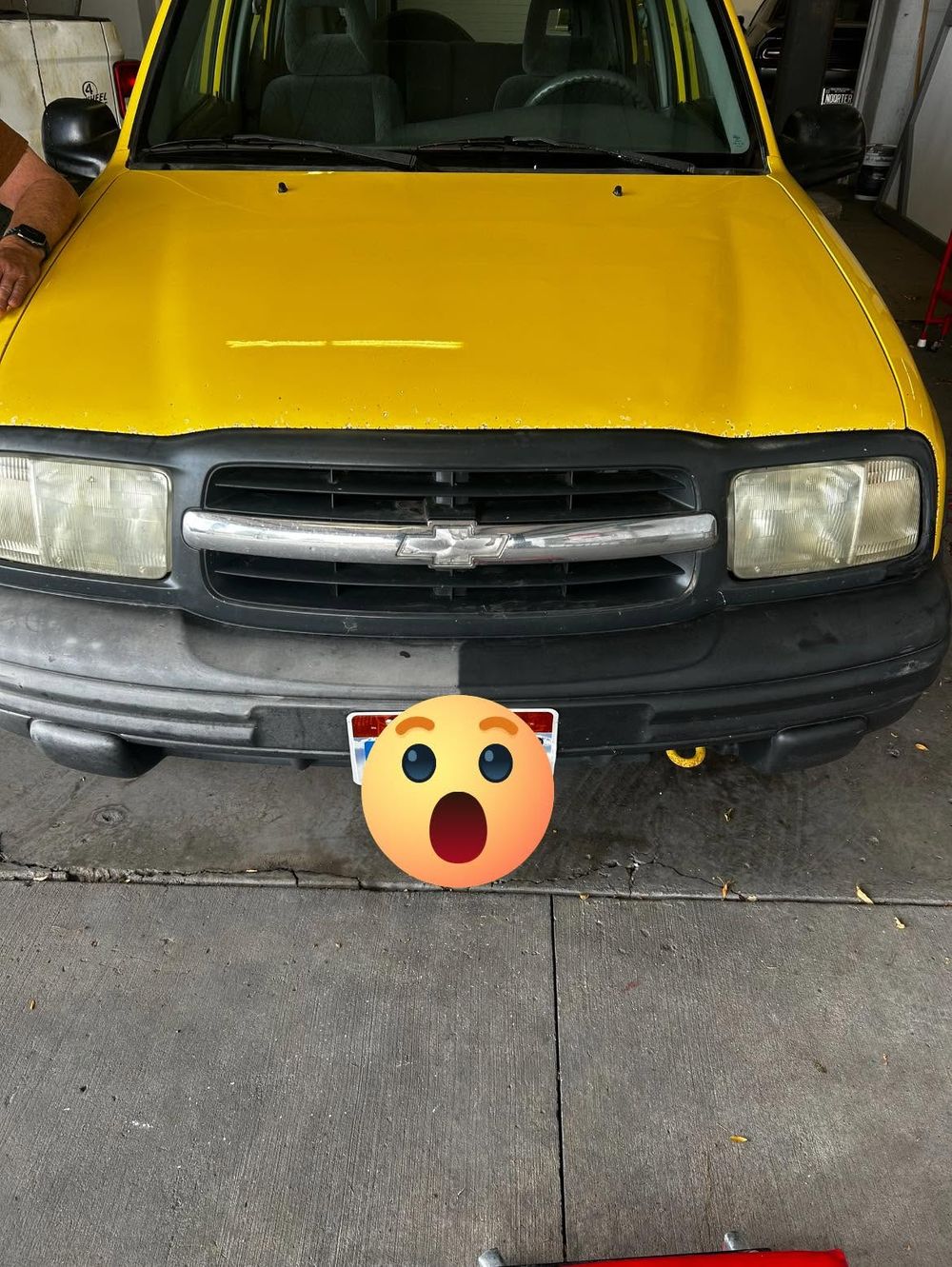 Chevy Tracker front bumper with faded gray trim on one side and restored black trim on the other, trim restoration in Richfield, Utah